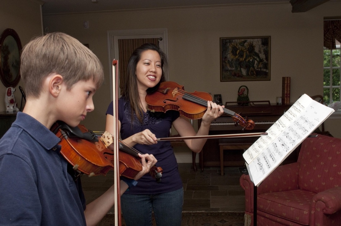 Miss Betty teaching a student alongside sheet music